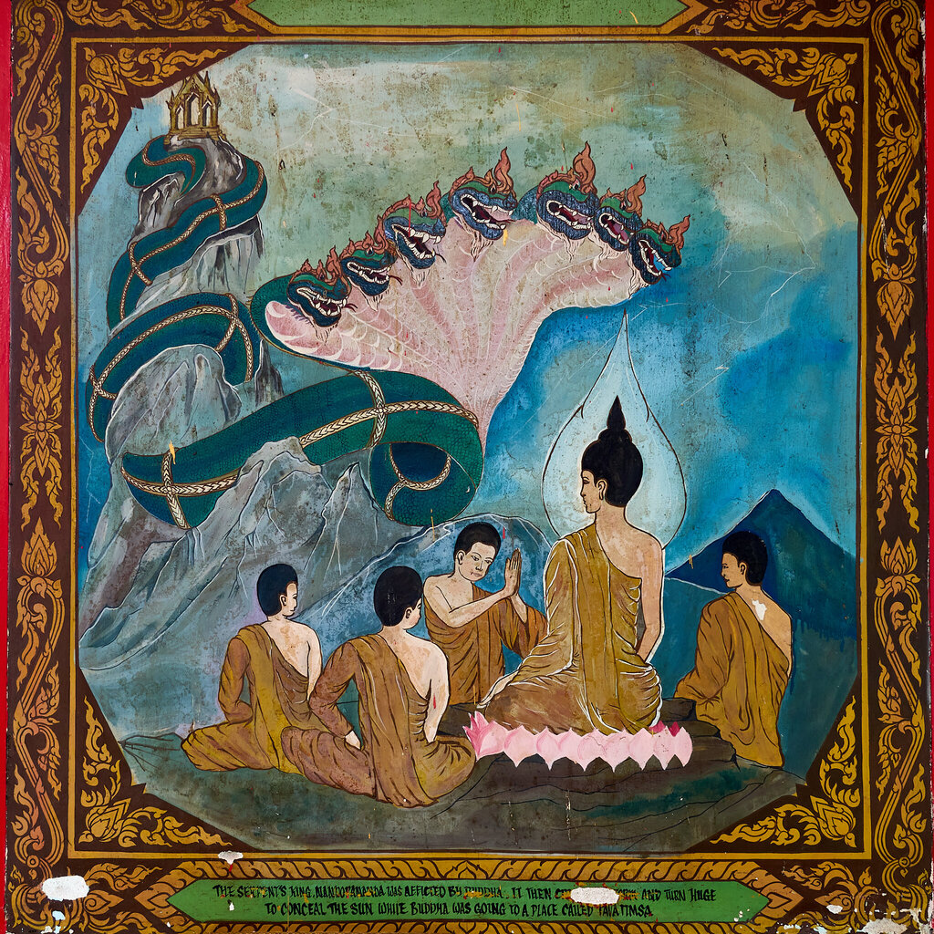 A colourful mural showing the Buddha and monks beneath the great green serpent Nandopananda